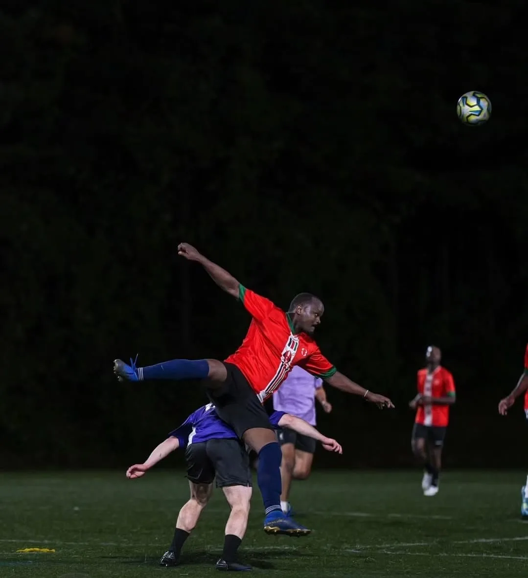 A JFC player in red going airborne in a challenge as an opponent tumbles below