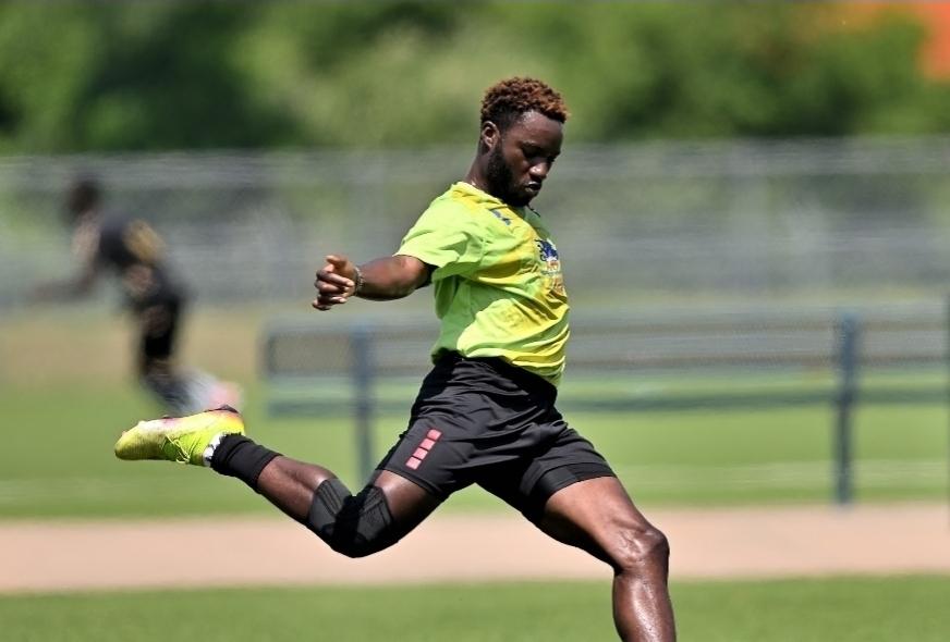 A JFC player in green striking the ball