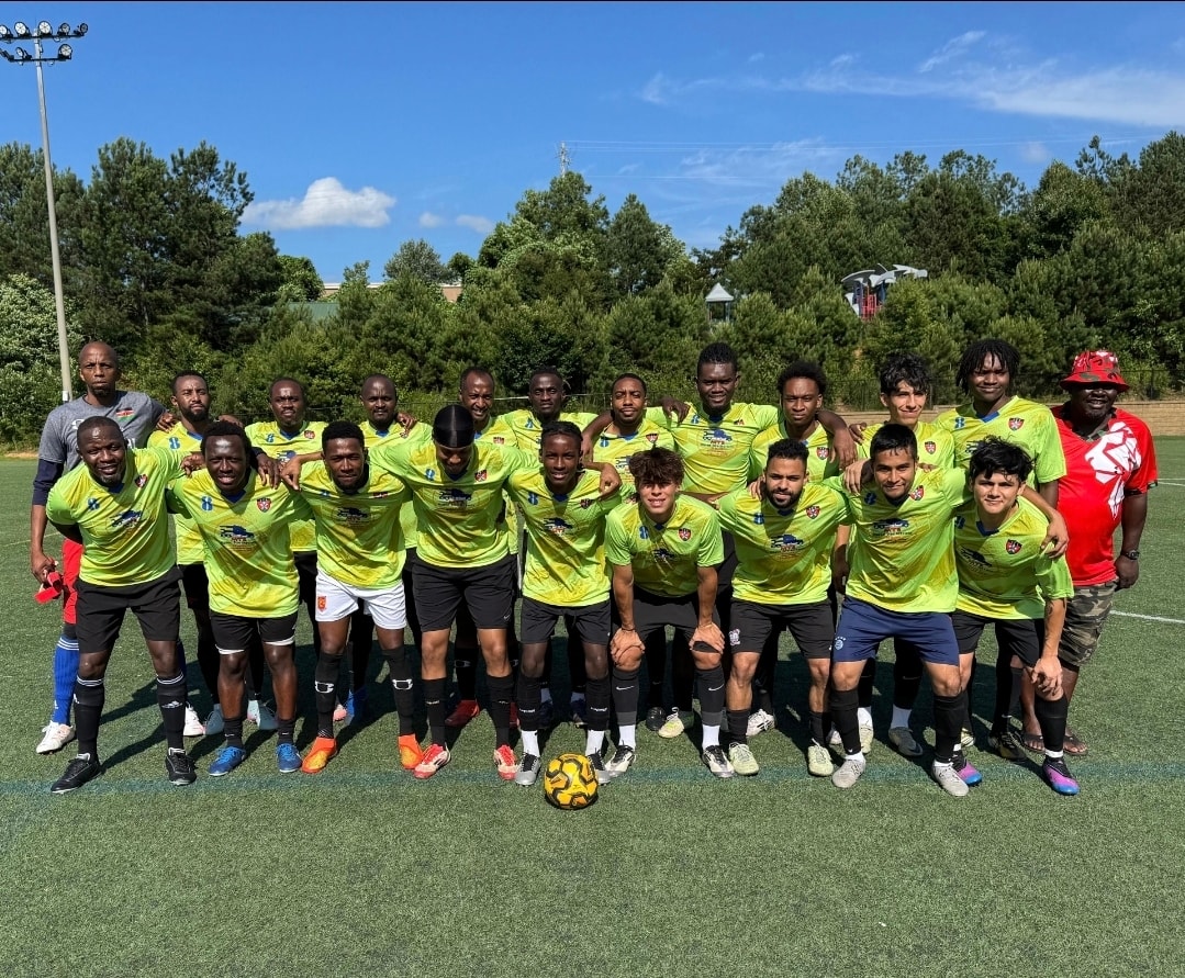 The JFC squad lined up in green kit on an Atlanta pitch